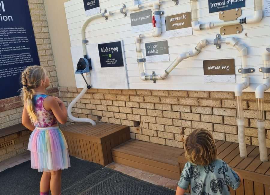 Children exploring water system display